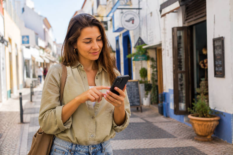 Uma mulher utiliza o Google Maps para encontrar uma loja local no Algarve